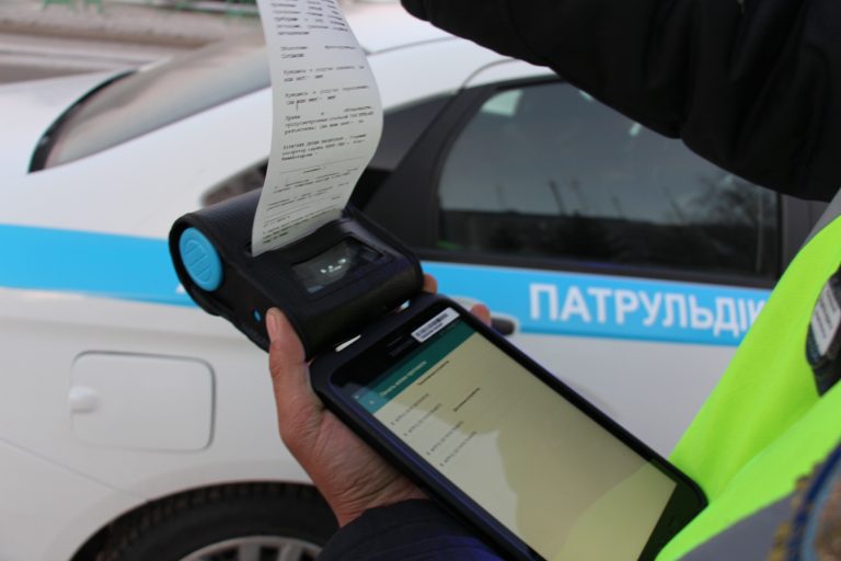 Полицейские Усть-Каменогорска оформляют протоколы на планшете