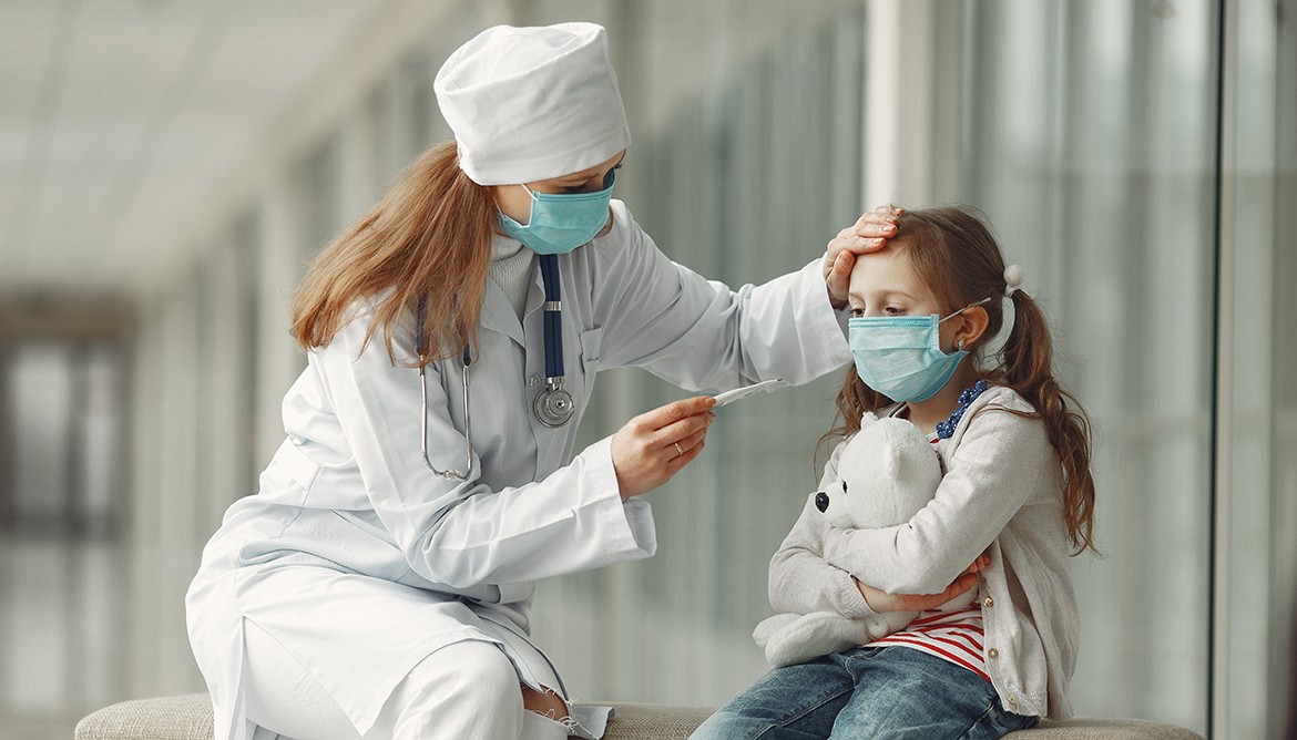 Doctor and a child in protective masks are in hospital